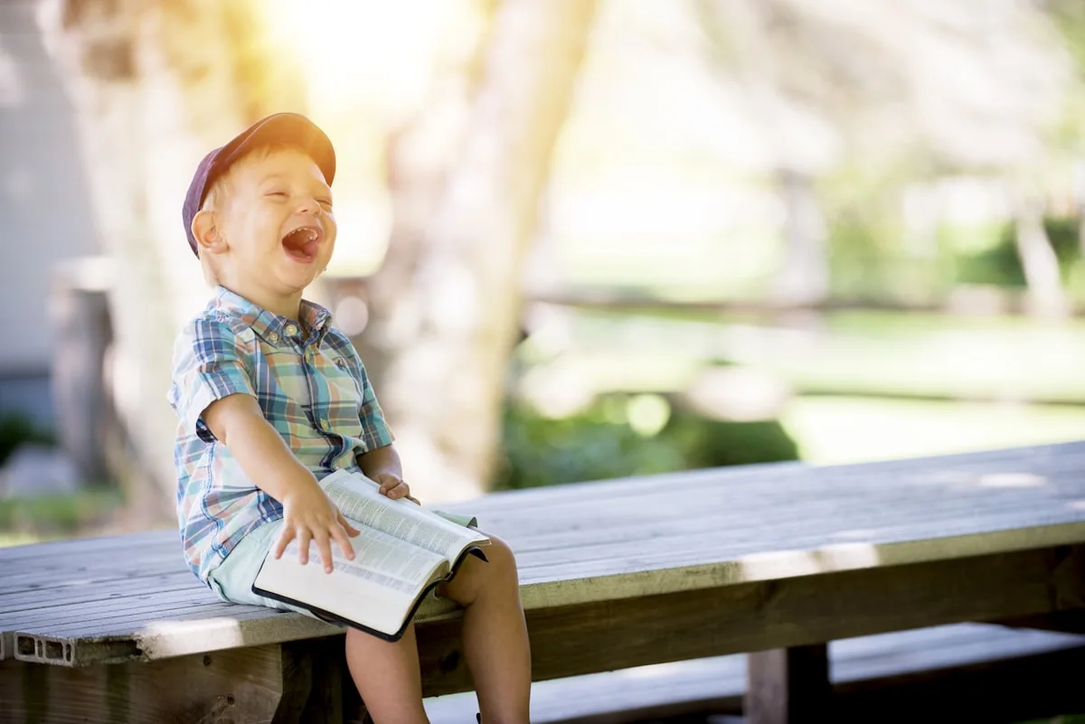 A child laughing over a favorite book
